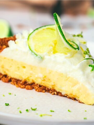 A slice of key lime pie on white plate