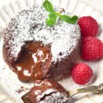 Half-eaten gluten-free lava cake with raspberries