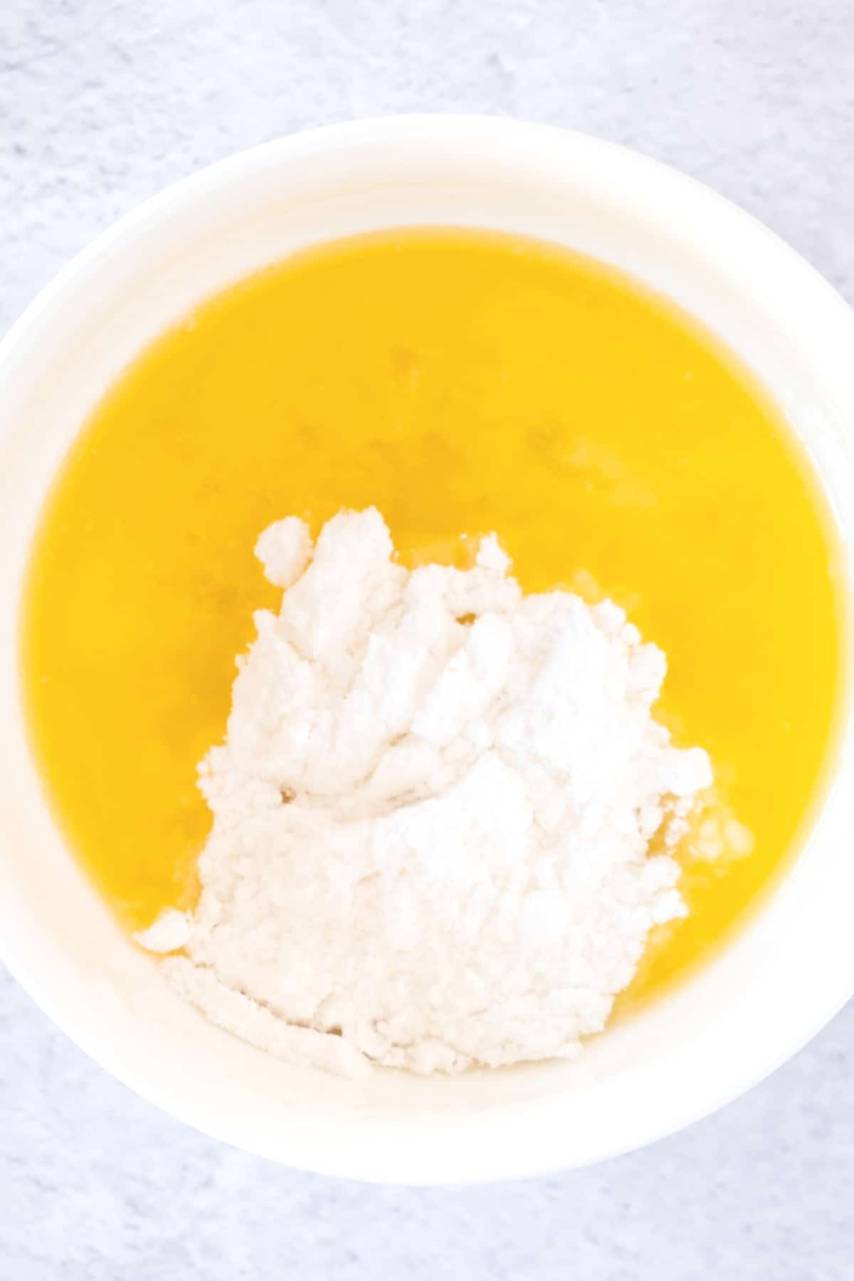 Powdered sugar and melted butter in a small white bowl.