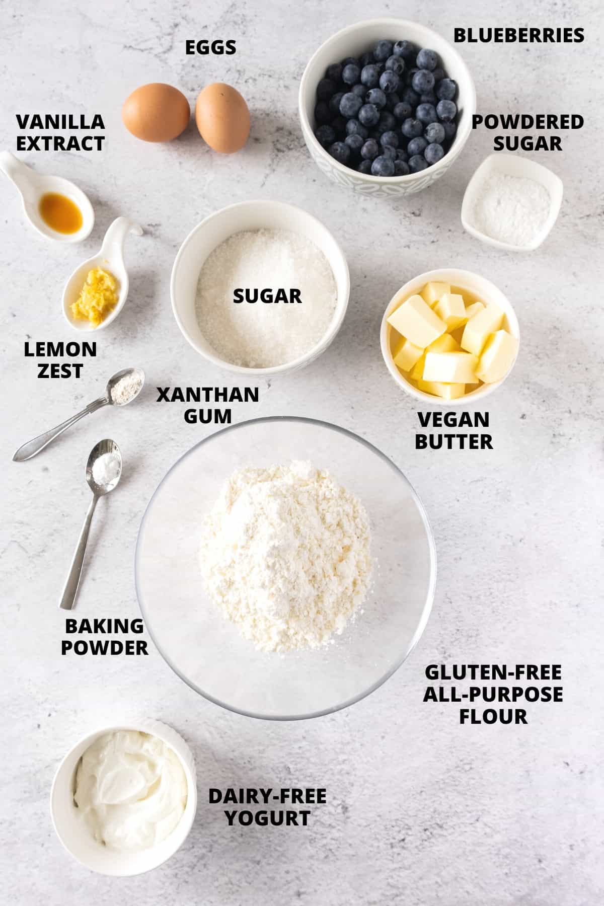 Ingredients for gluten-free lemon and blueberry cake recipe laid out on board.