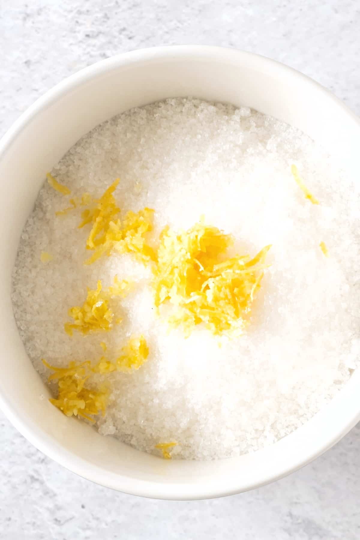 A bowl of sugar and fresh lemon zest.