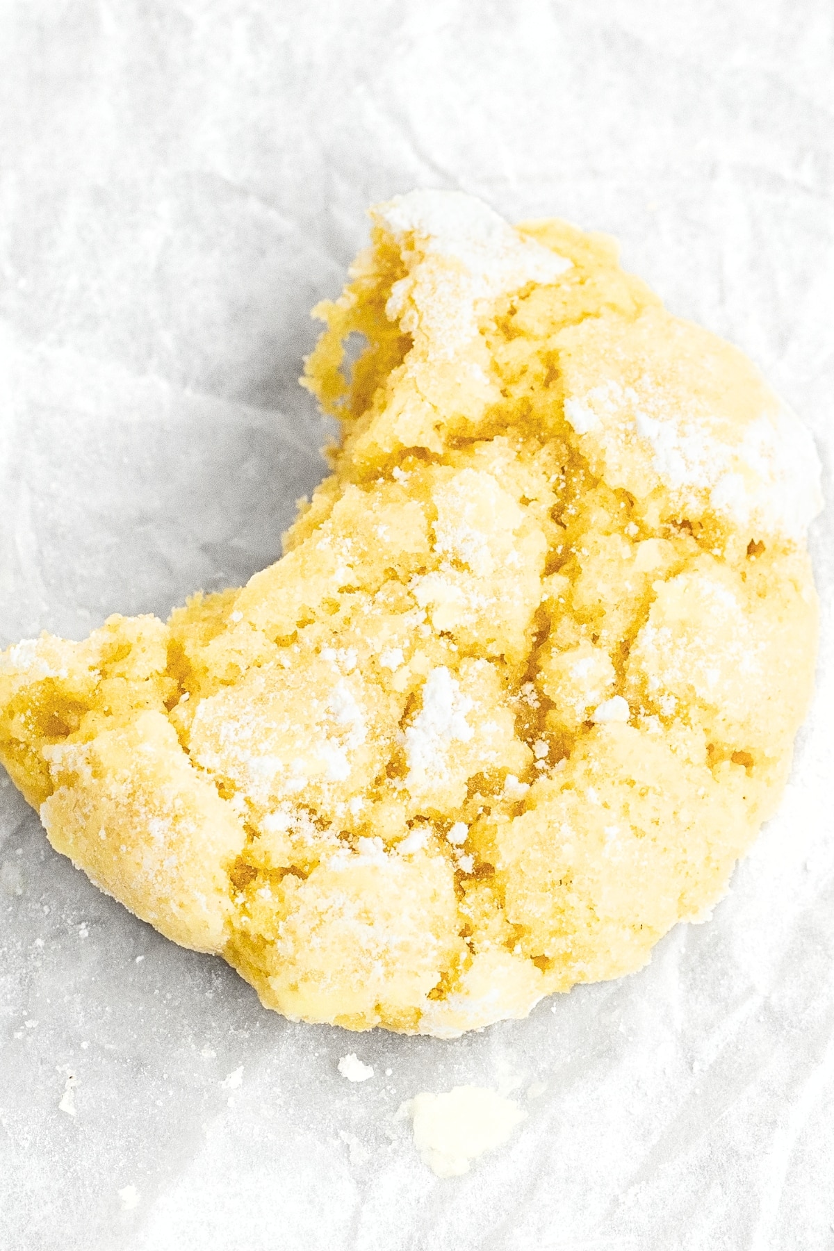 Up close shot of a half-eaten lemon crinkle cookie.