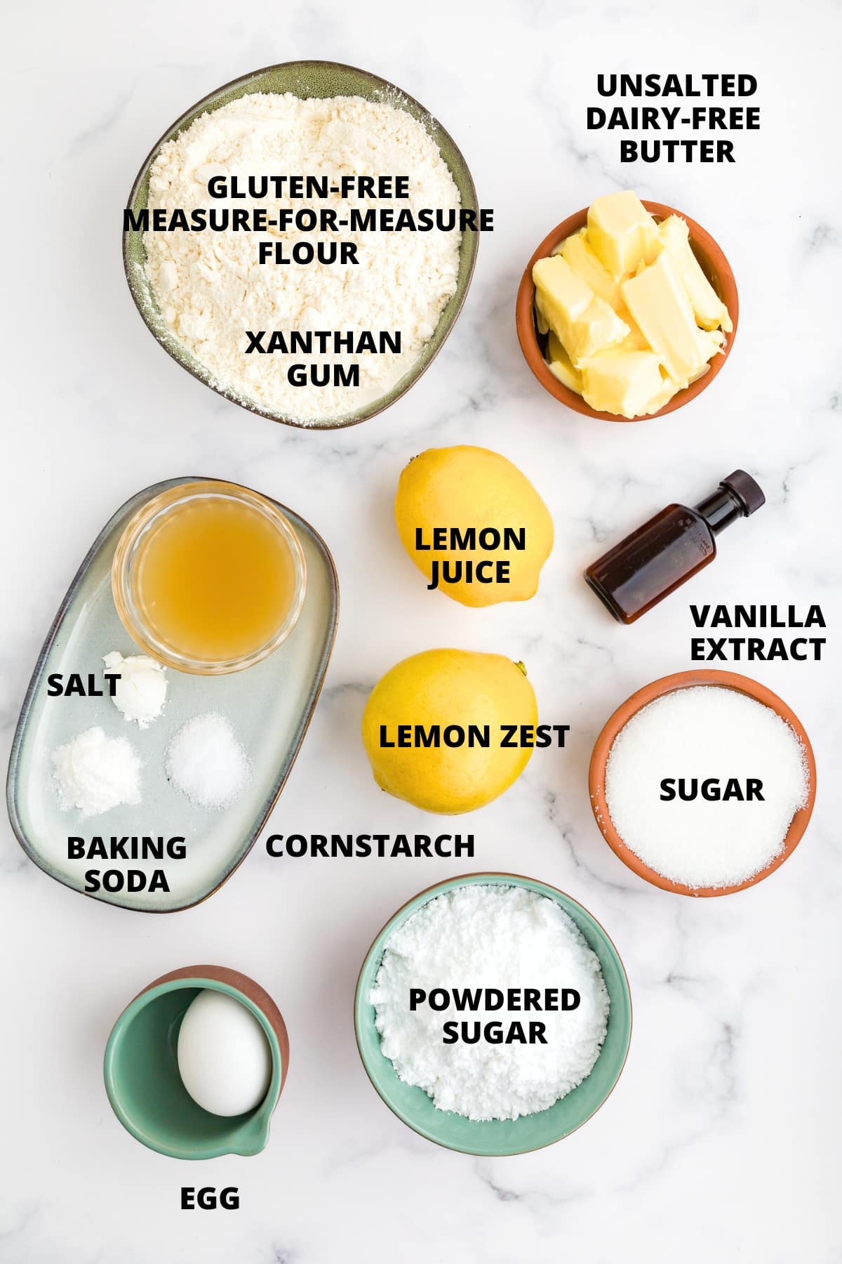 Ingredients for gluten-free lemon crinkle cookies recipe laid out on marble board.