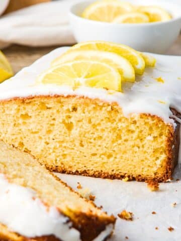 Half-eaten loaf of gluten-free lemon drizzle cake.