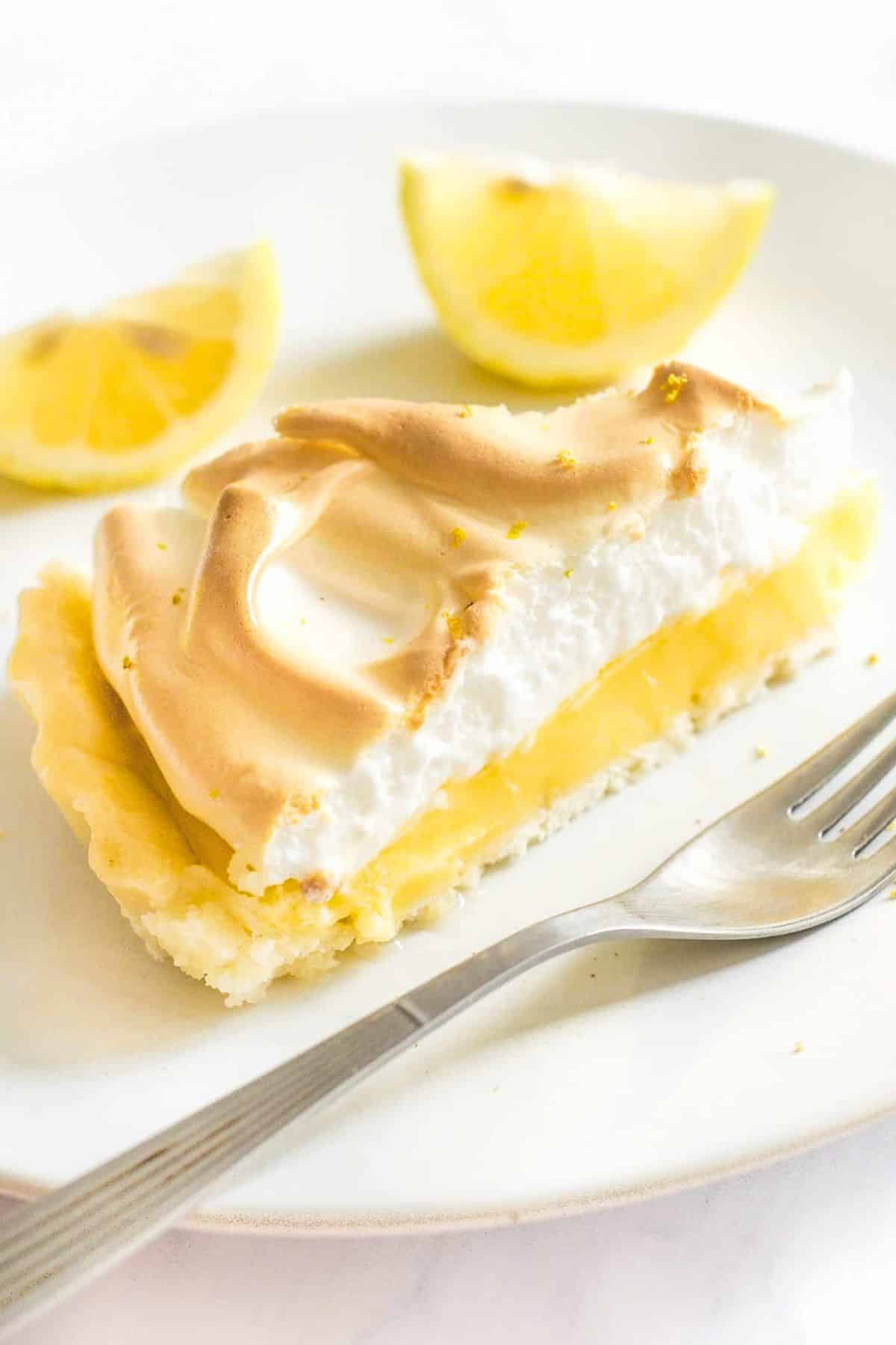 Up close shot of a slice of gluten-free lemon meringue pie on plate.