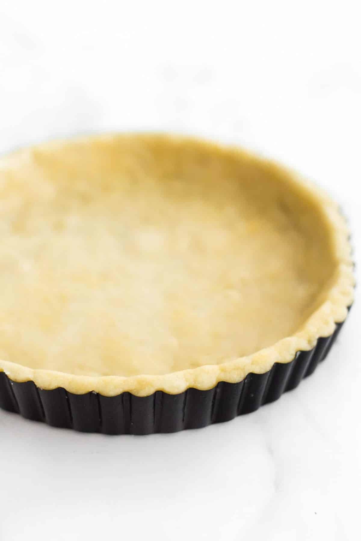 Up close shot of pie crust dough pressed into pie tin.