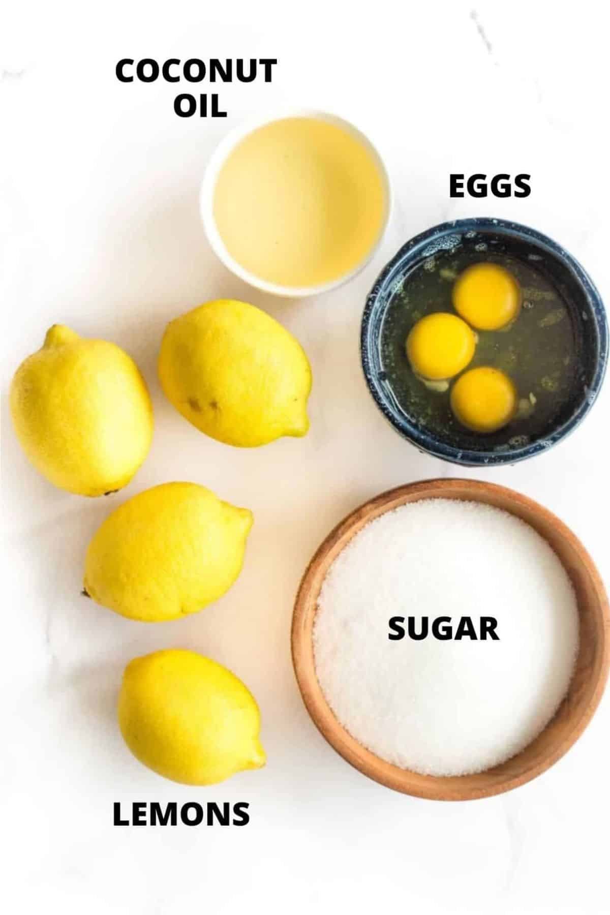 Top down view of ingredients for lemon curd laid out on white board.