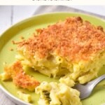 Half-eaten portion of mac and cheese on a plate.