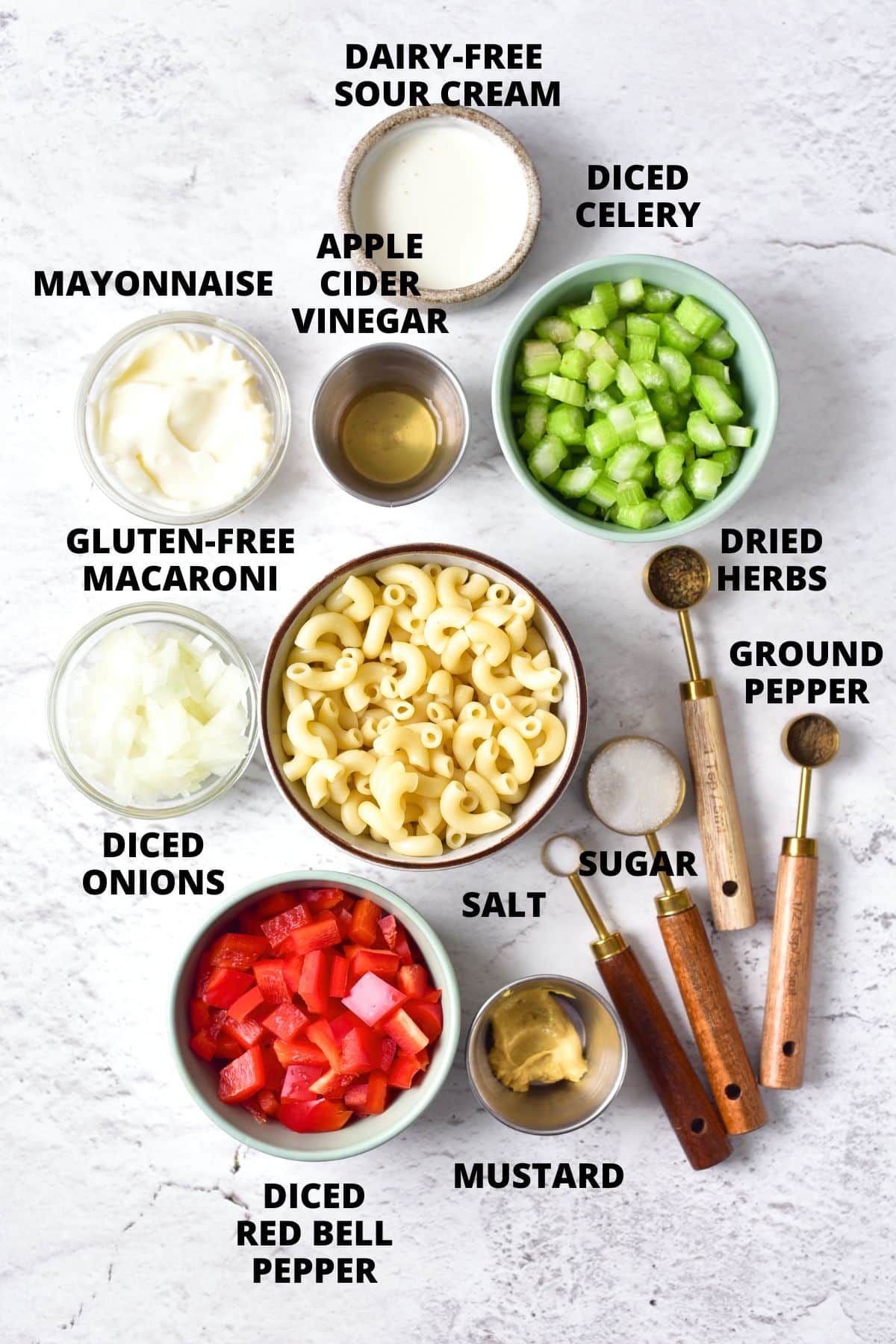 Ingredients for macaroni salad recipe laid out on marble board.