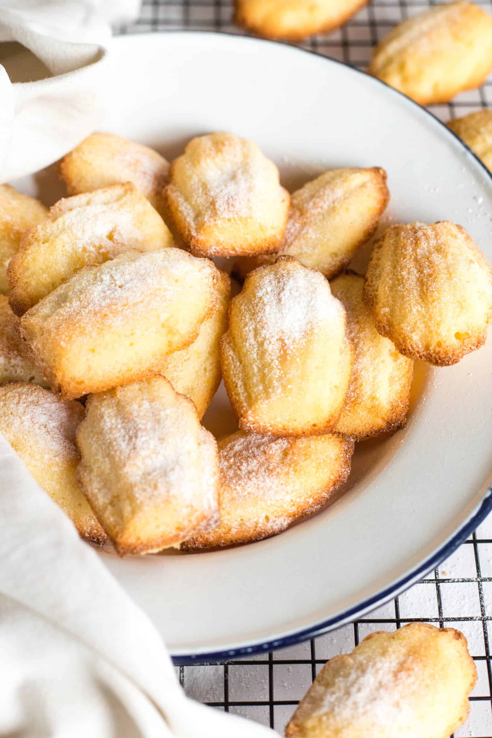 Up close image of gluten-free madeleines on a white plate.