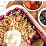 A scoop of ice cream on mixed berry crumble.