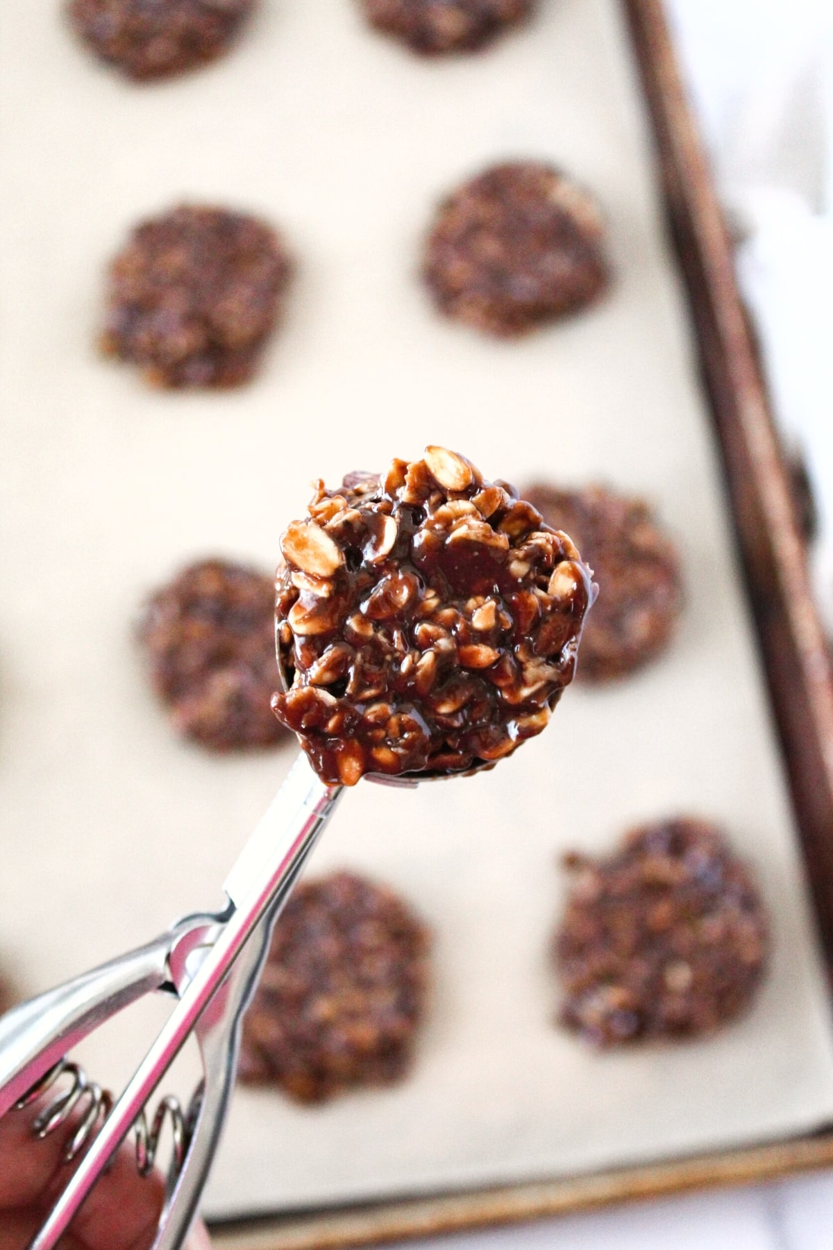 Using cookie scoop to scoop up cookie dough.