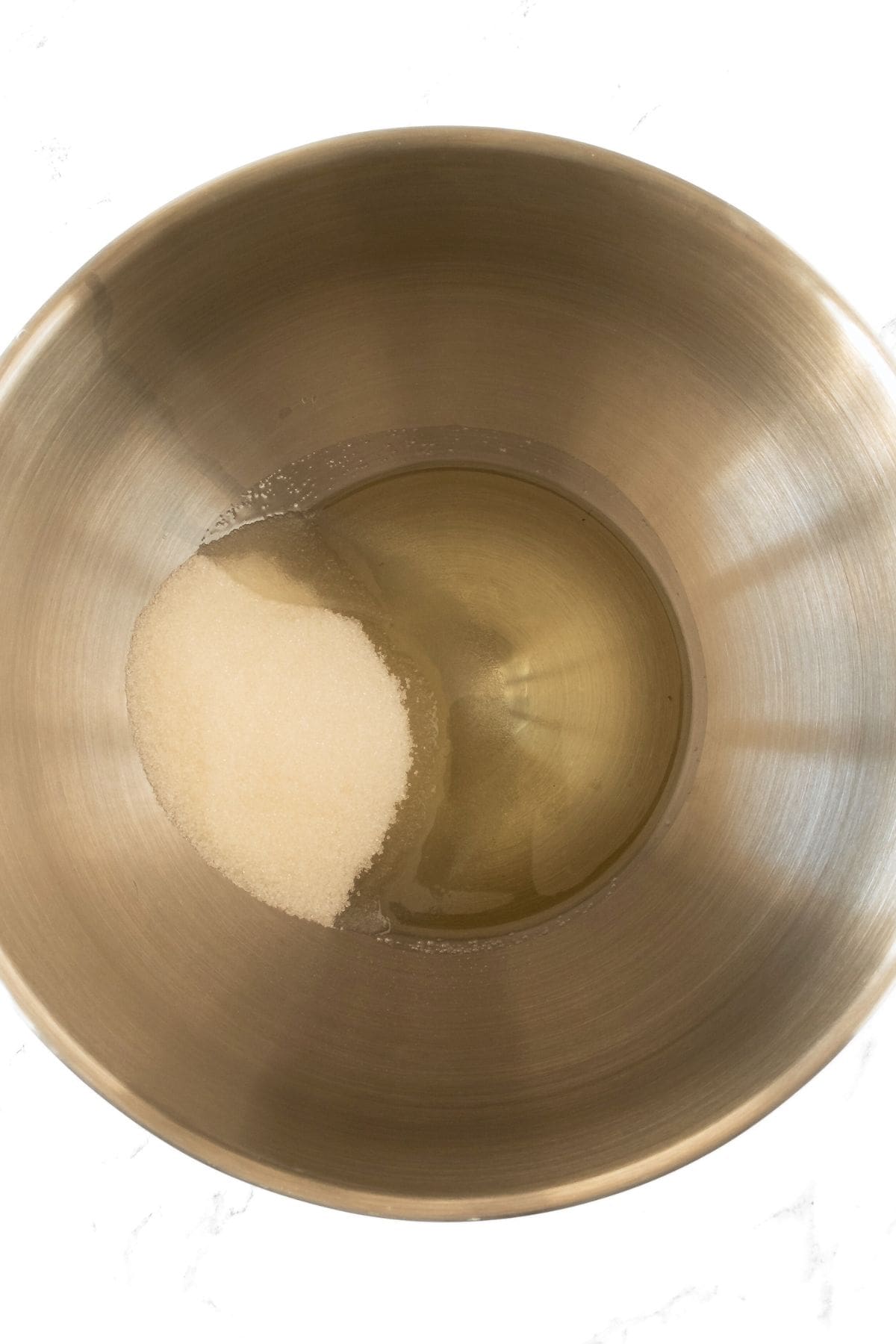 Oil and sugar in metal mixing bowl
