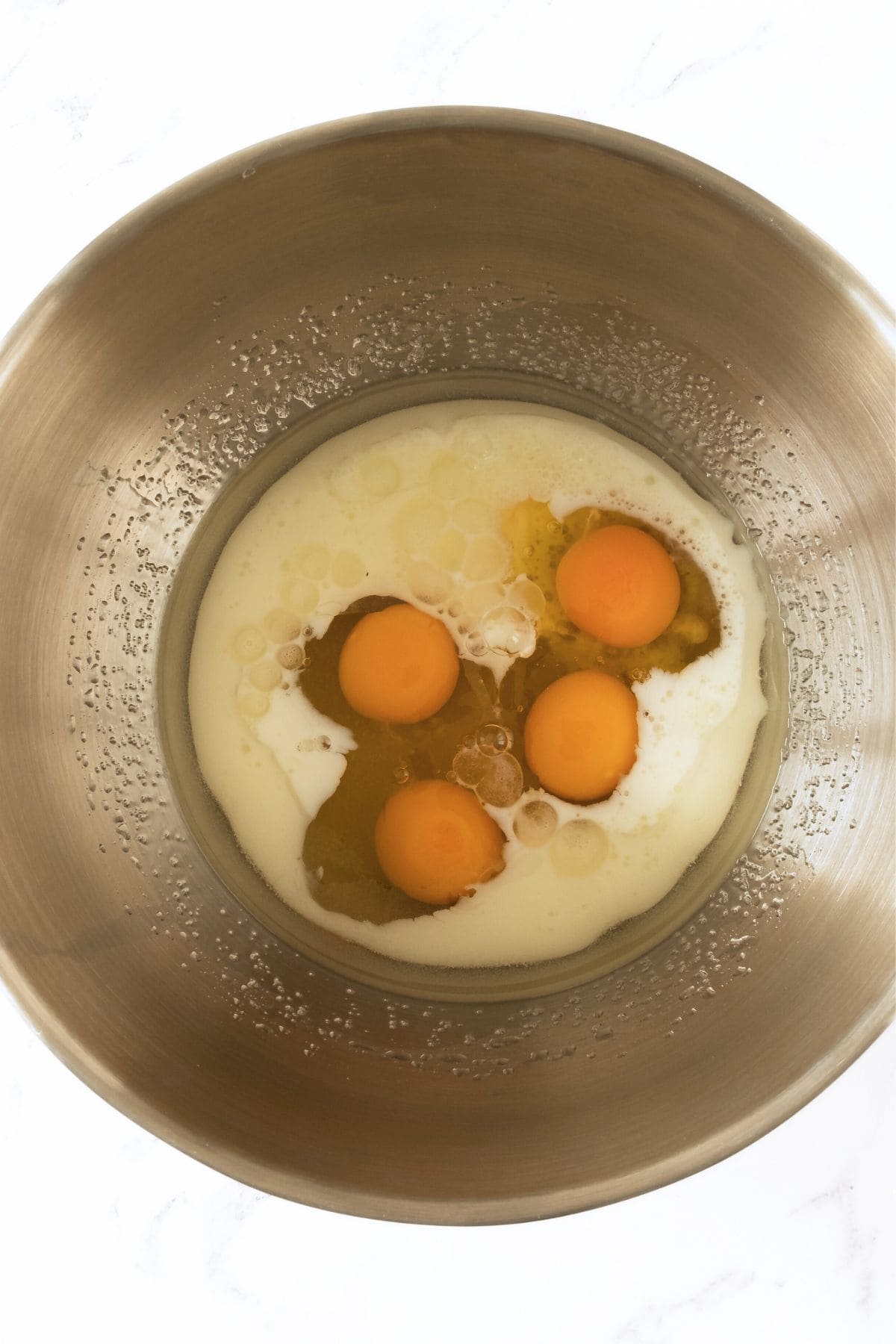 Eggs and milk in metal bowl