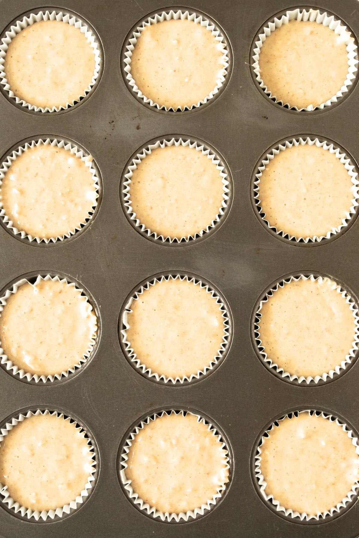 Muffin batter in paper liners in muffin tin.