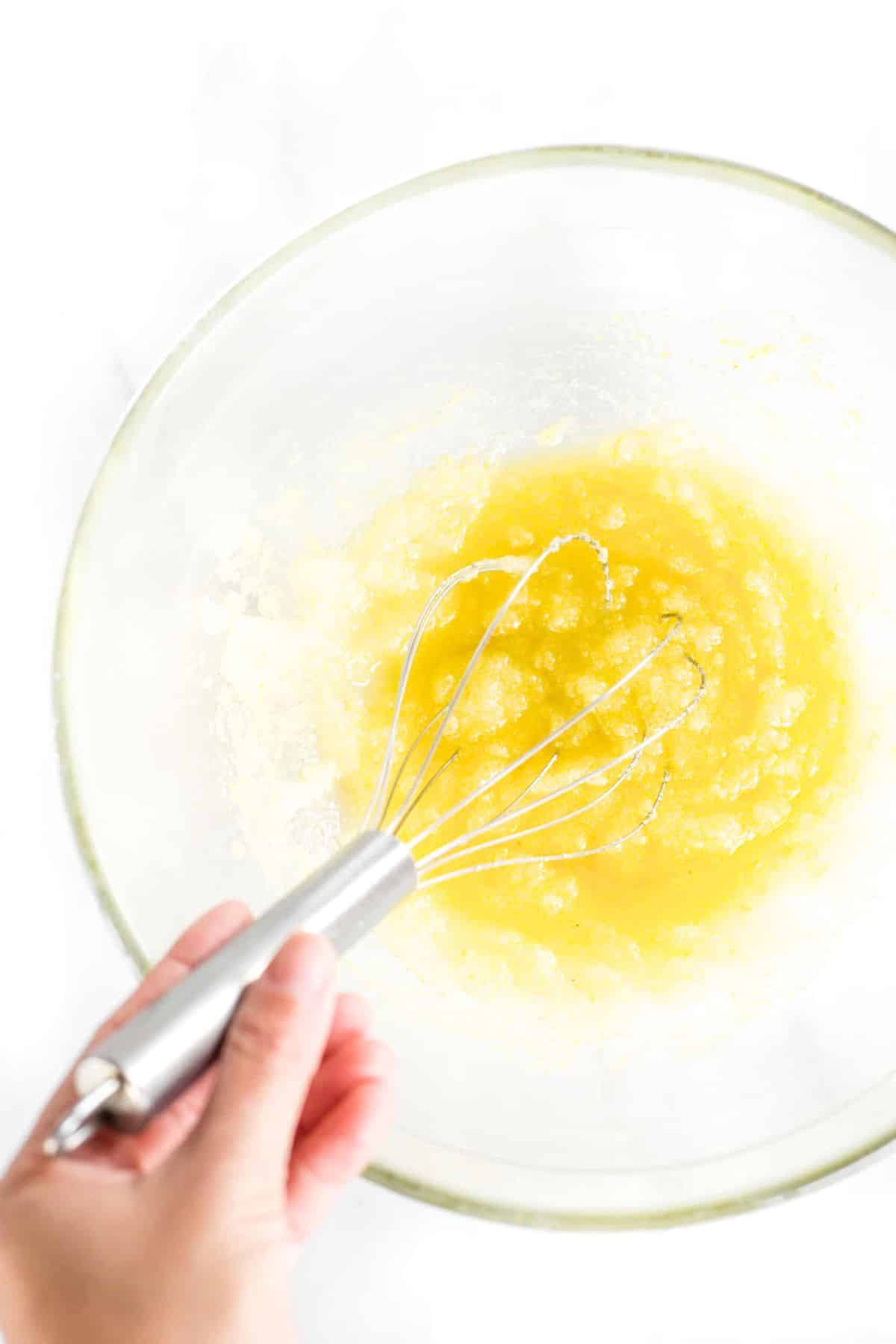 Gluten-Free Lemon Olive Oil Cake (Dairy-Free) Whisking yellow mixture in glass bowl.