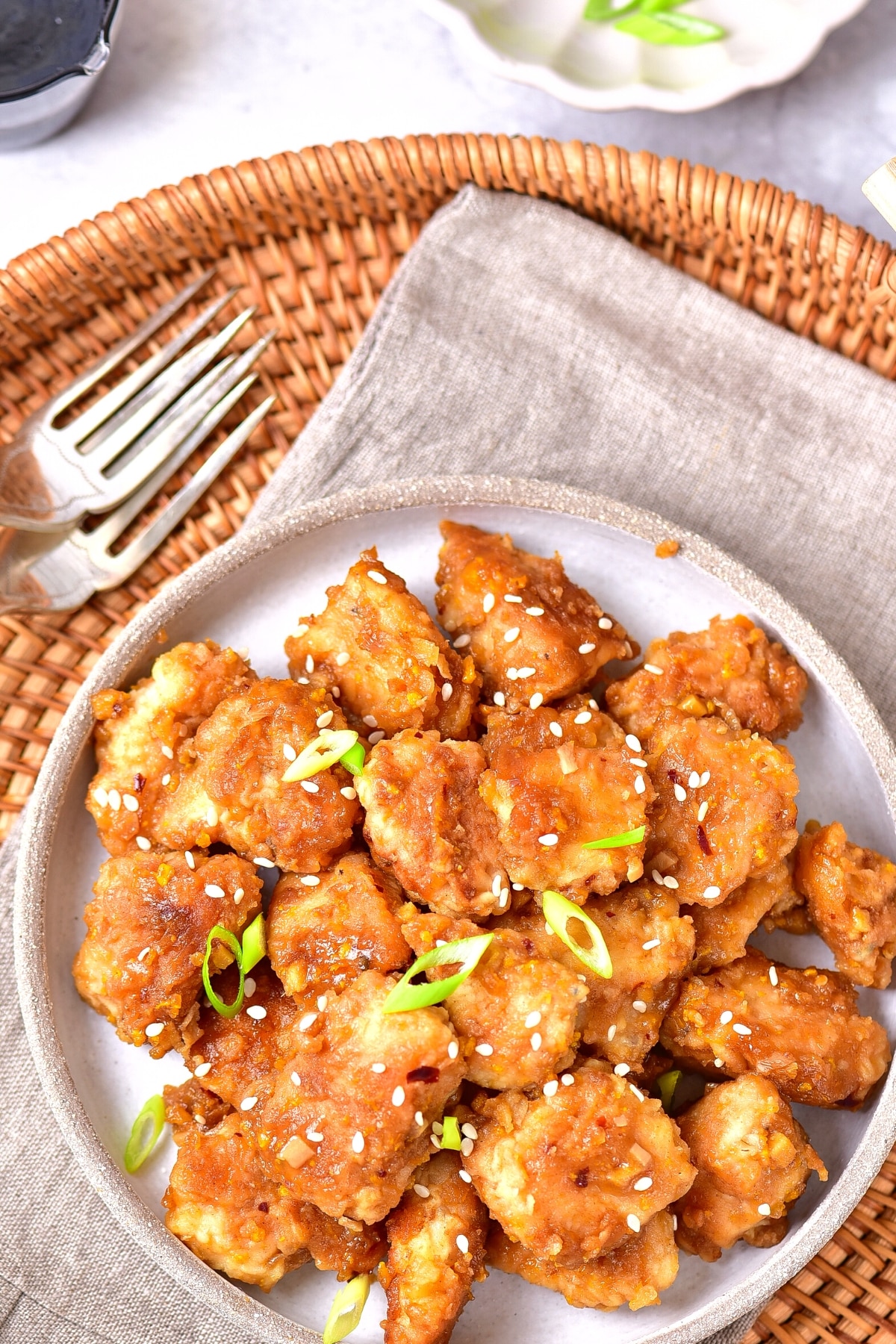 Easy Gluten-Free Orange Chicken Recipe (Dairy-Free) Top down view of a plate of gf orange chicken on a kitchen towel.