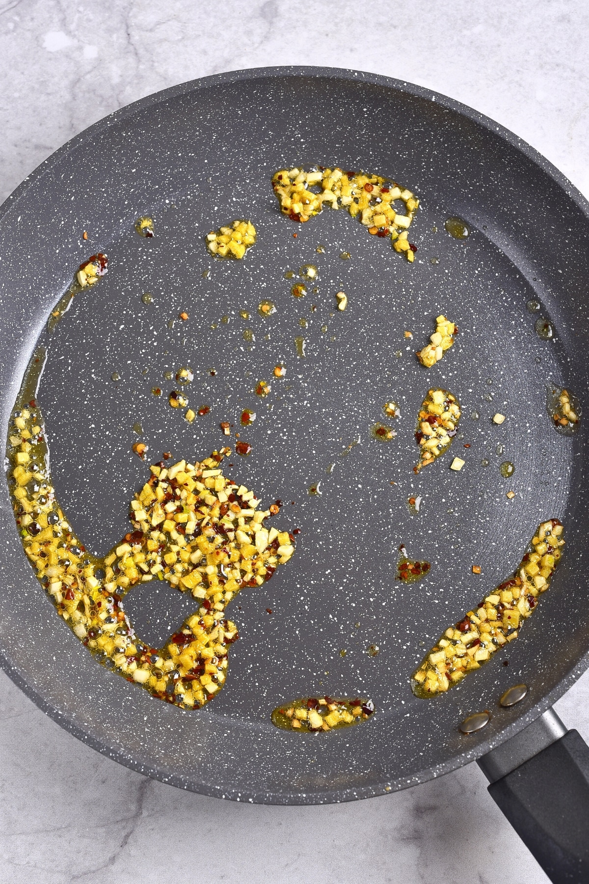 Copycat Panda Express Orange Chicken Gluten-Free Sautéing minced garlic and ginger in a skillet.