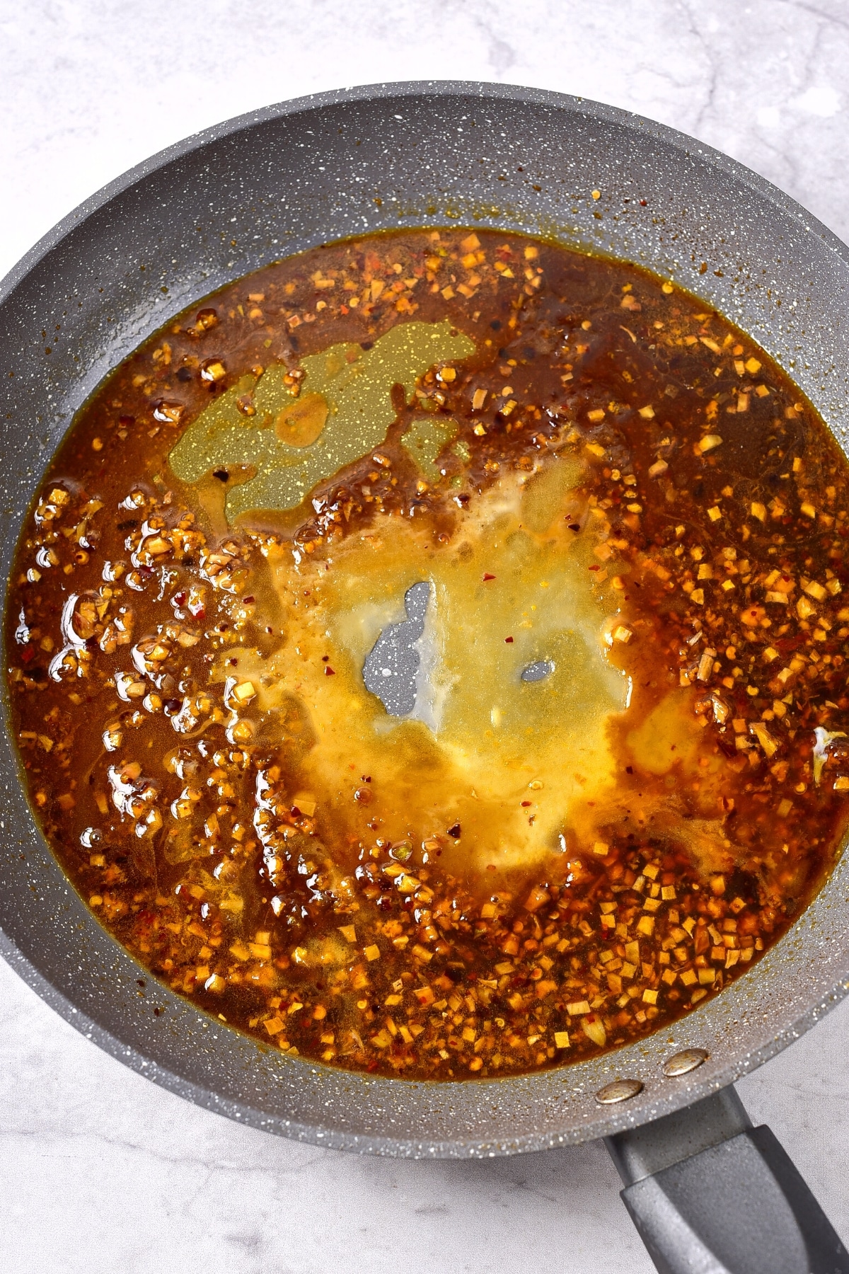 Gluten-Free Orange Chicken Sauce Preparing gluten-free orange chicken sauce in skillet.