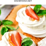 Half-eaten pavlova nests topped with strawberries and mint.