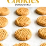 Hand pulling a baking sheet with peanut butter cookies.