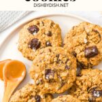 A spoon of peanut butter on plate of chocolate peanut butter oatmeal cookies