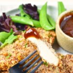 Holding up a forkful of pecan chicken dipped in sauce