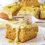 Fork cutting into a slice of pistachio cake
