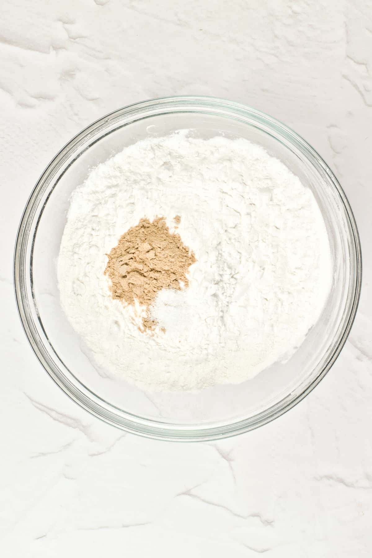 A glass bowl with flour and psyllium husk powder.