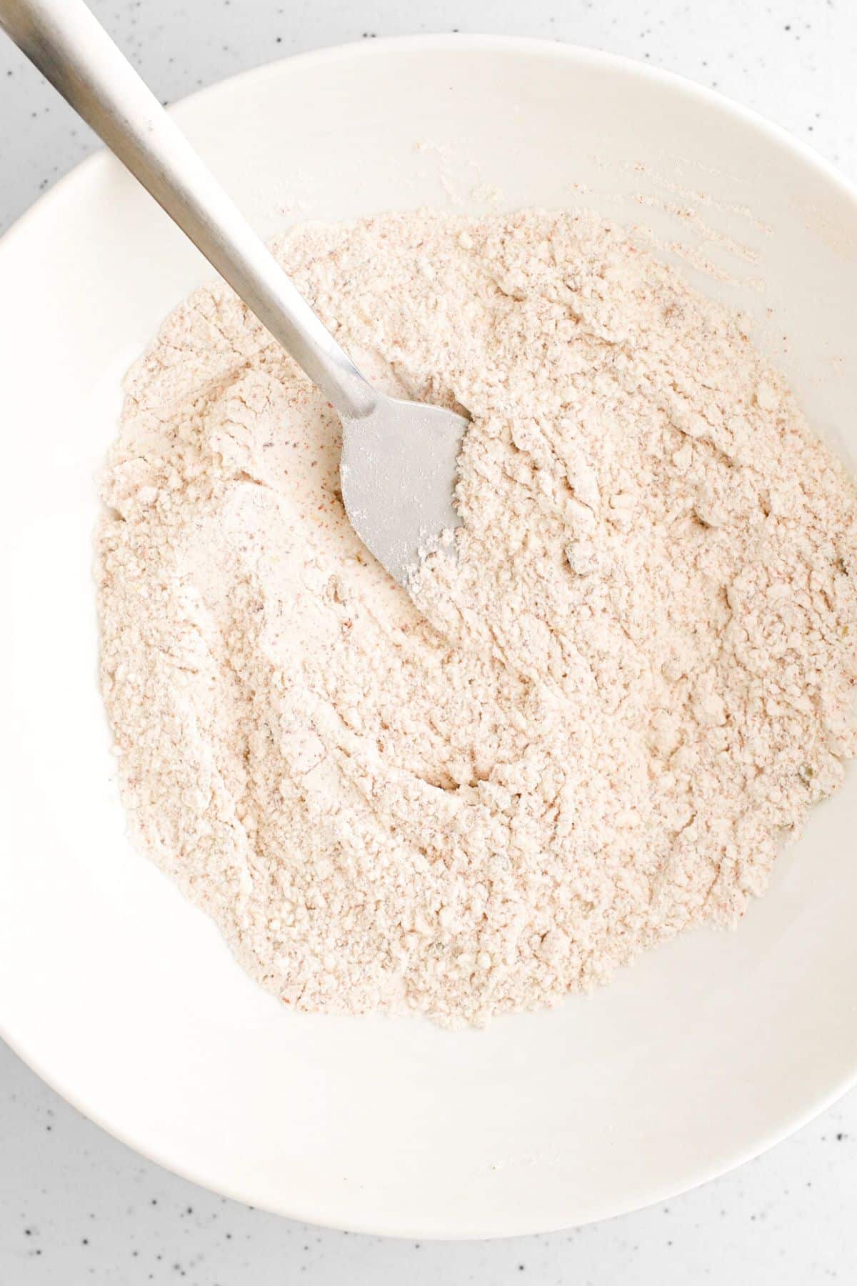 Whisking flour mixture in white bowl.