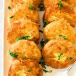 Potato fritters arranged on white plate.