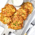Top down view of potato latkes on wooden board.