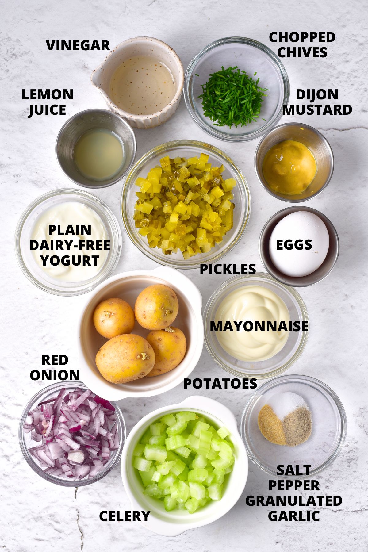 Ingredients for gluten-free potato salad laid out on marble board.
