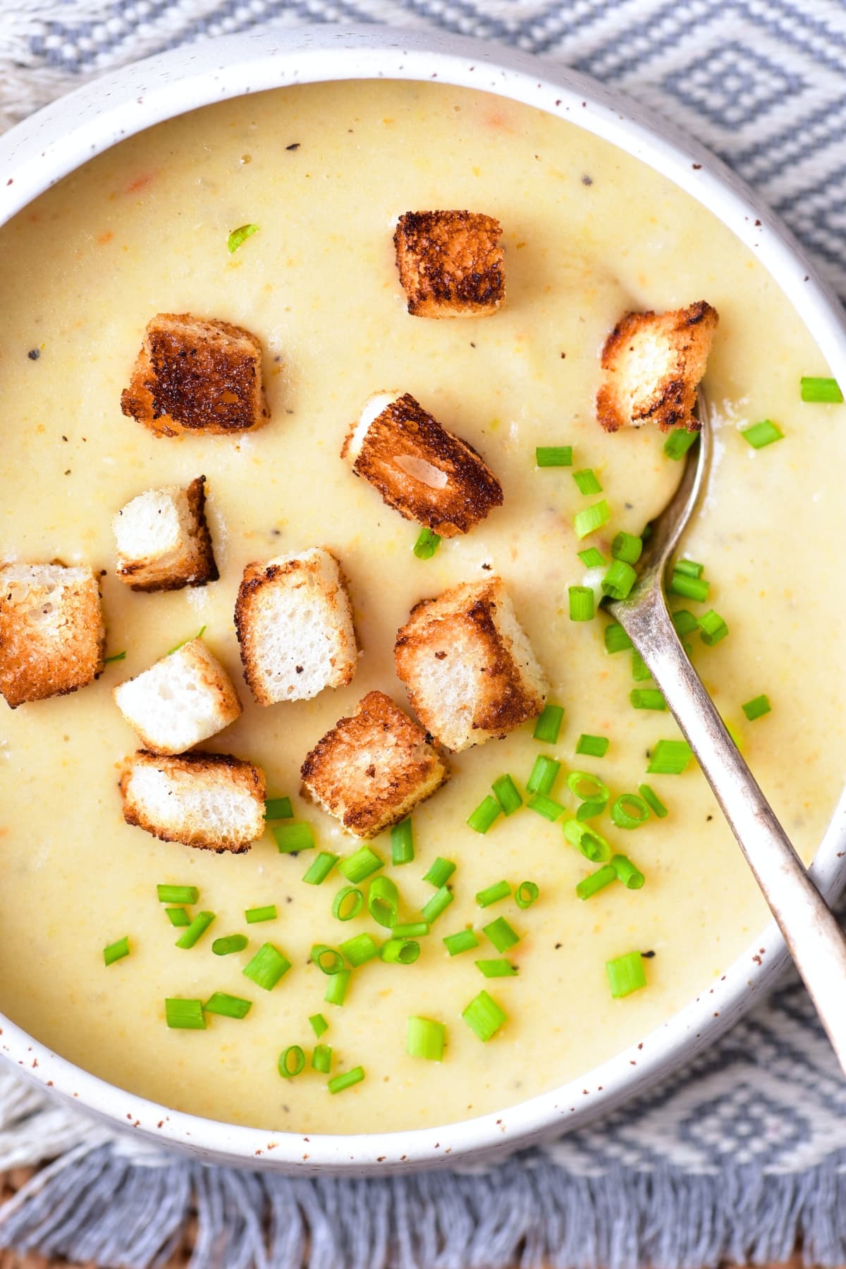 Scooping into a bowl of creamy gluten-free potato soup.