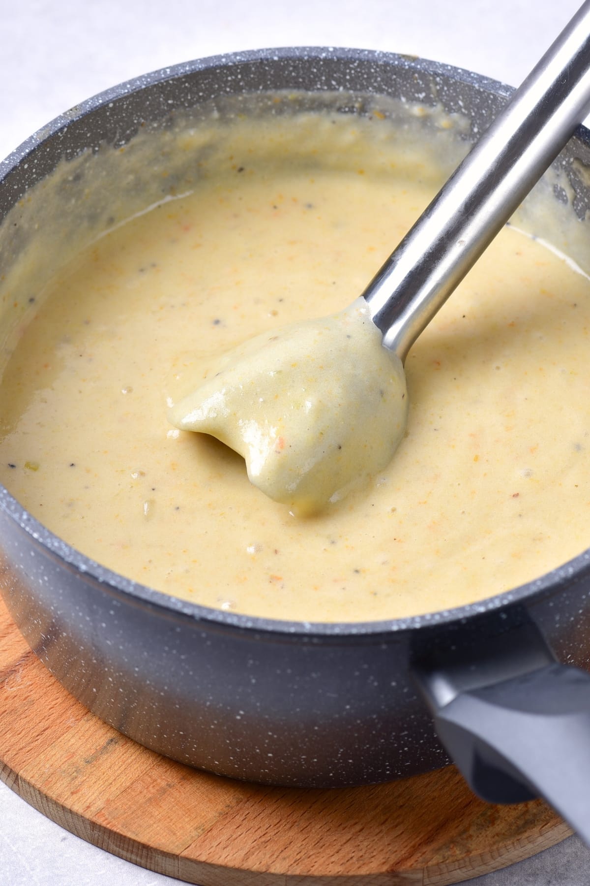 Processing potato soup with immersion blender.