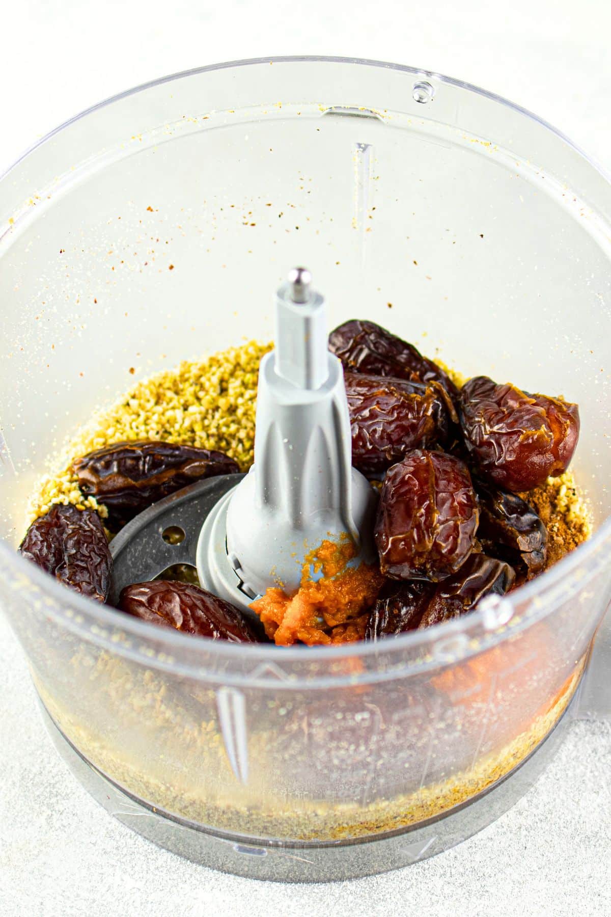 Dates, pumpkin puree, and ground nuts in food processor.