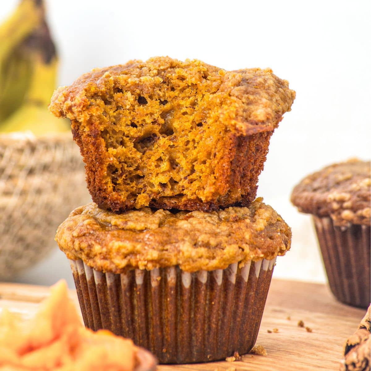 A stack of half-eaten gluten-free pumpkin banana muffins.