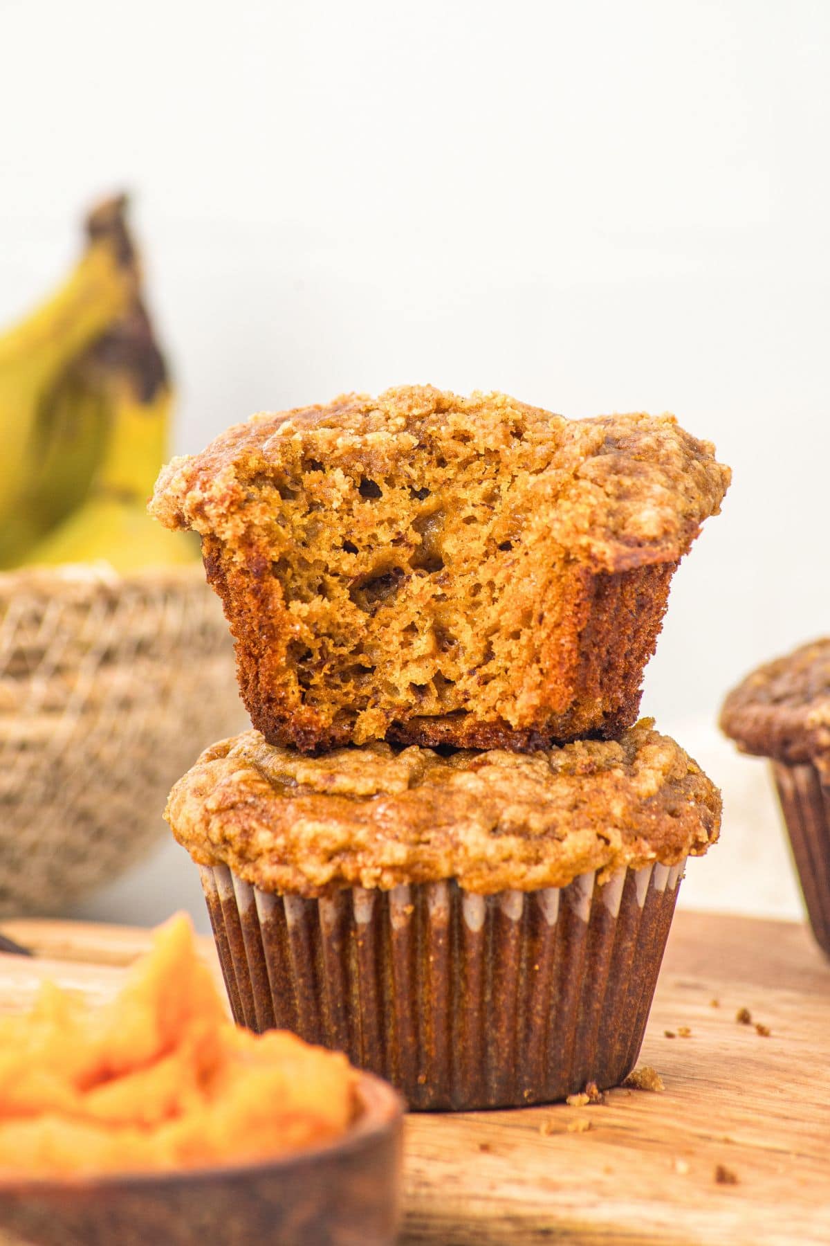 Half-eaten pumpkin banana muffins stacked on each other