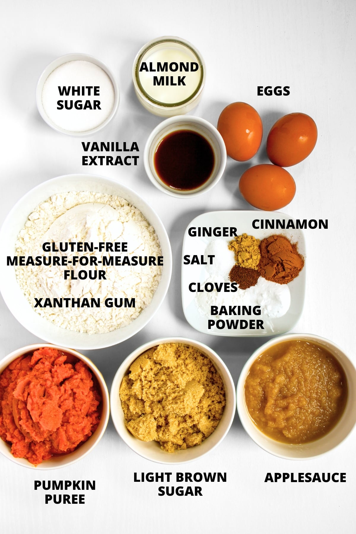 Ingredients for gluten-free pumpkin cake recipe laid out on white board.