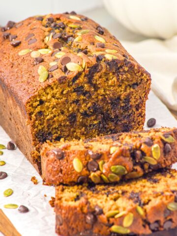 Half-sliced loaf of gluten-free pumpkin chocolate chip bread.