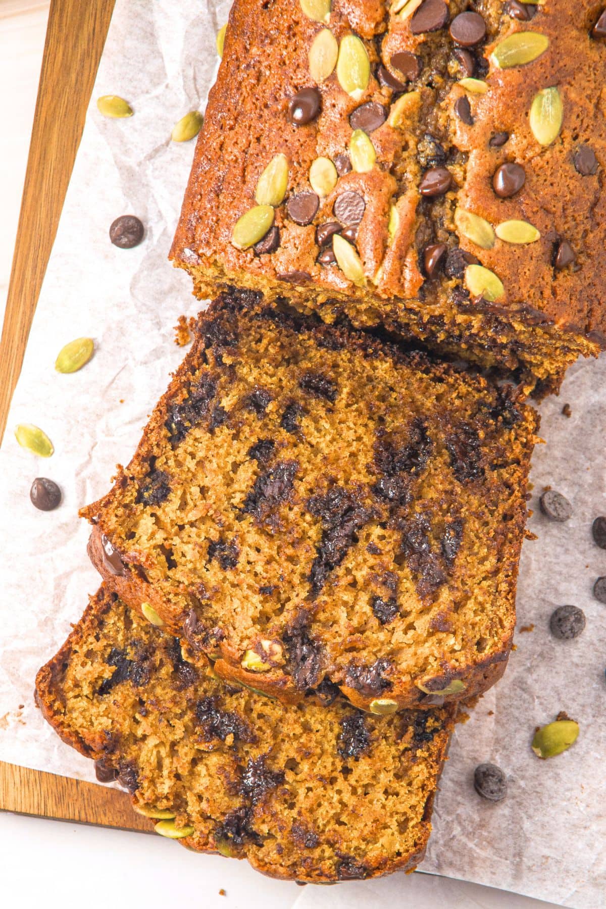 Top down view of sliced gluten-free pumpkin chocolate chip bread on parchment.