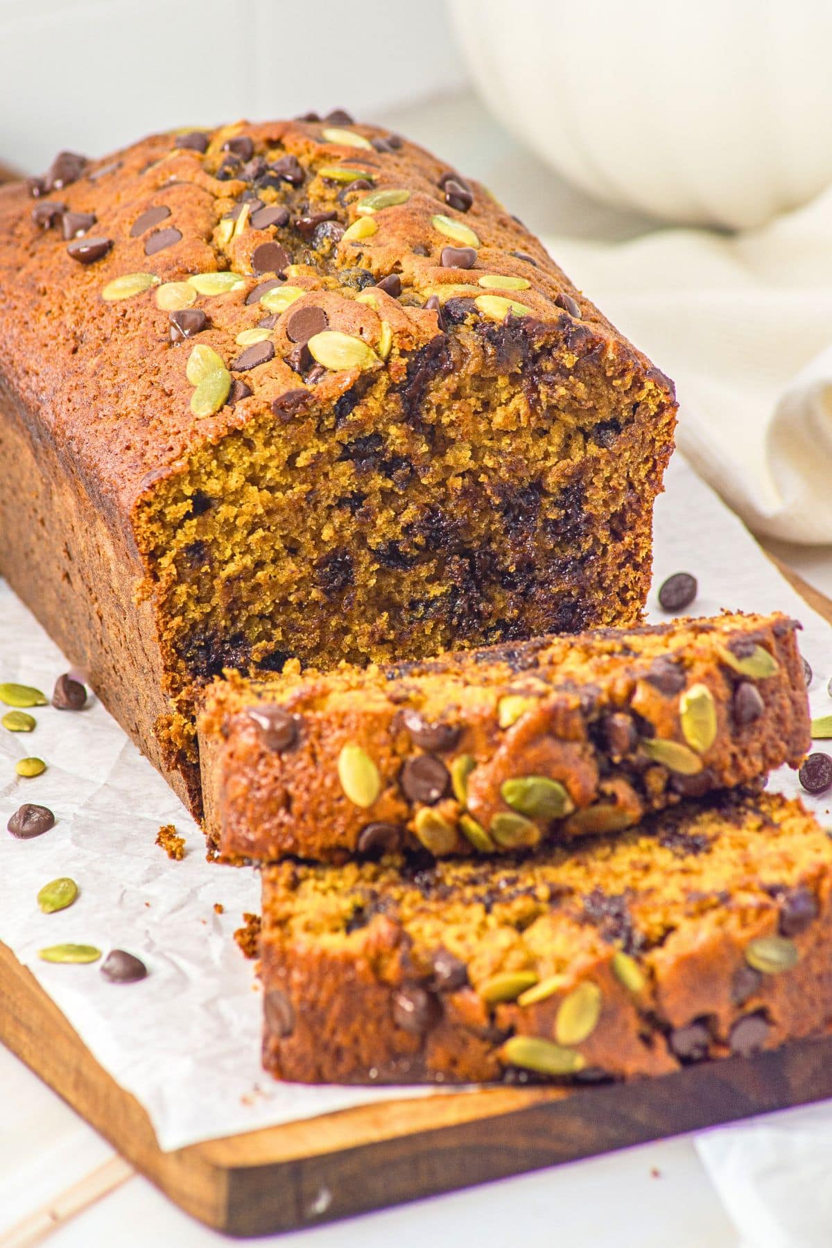 Up close view sliced gluten-free chocolate chip pumpkin bread on board.