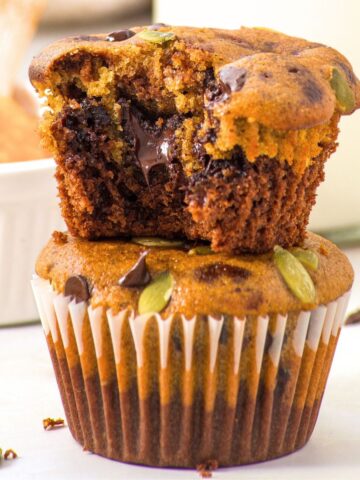 Gluten free pumpkin chocolate chip muffins stacked on top of each other.