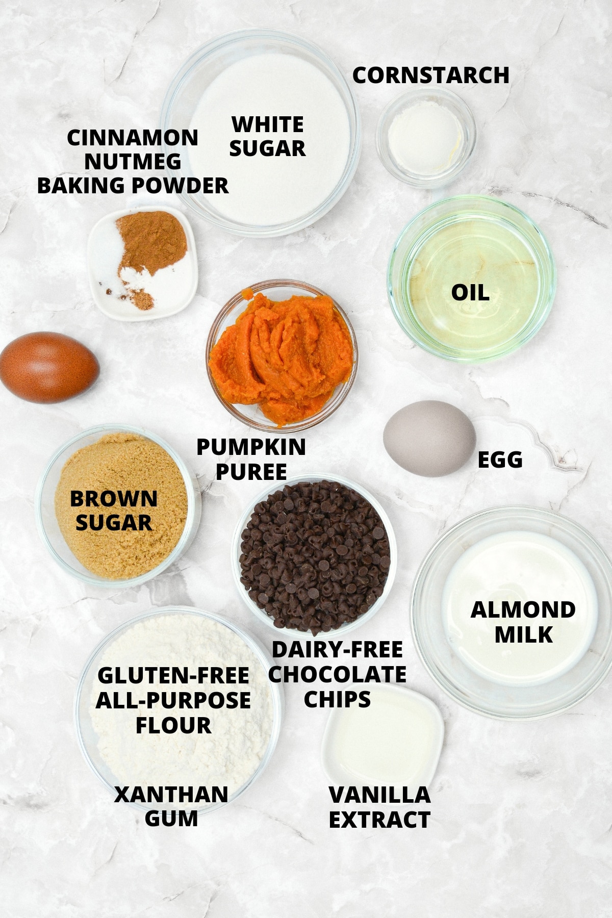 Ingredients for gluten-free pumpkin cupcakes recipe laid out on marble board.