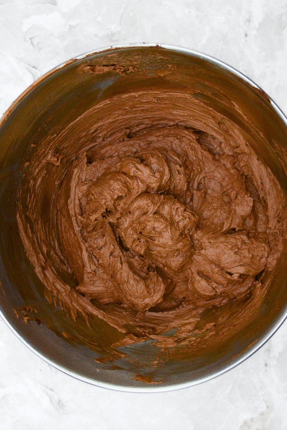 Chocolate frosting in metal bowl.