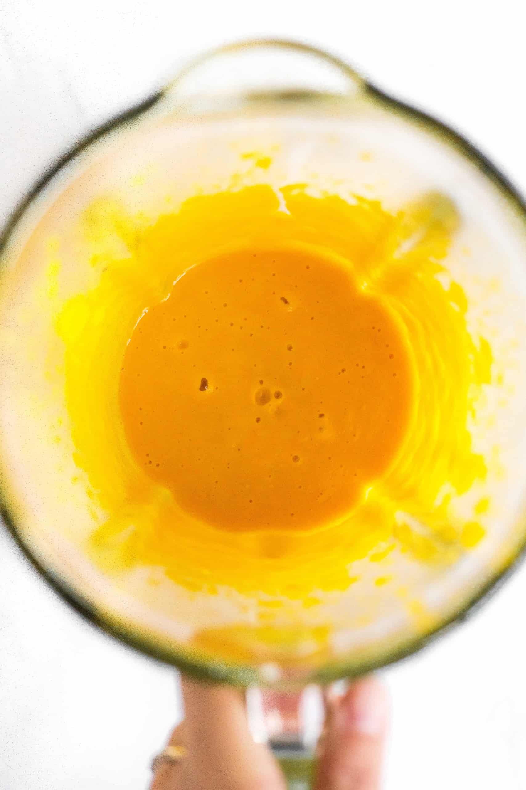 Orange liquid mixture in blender.