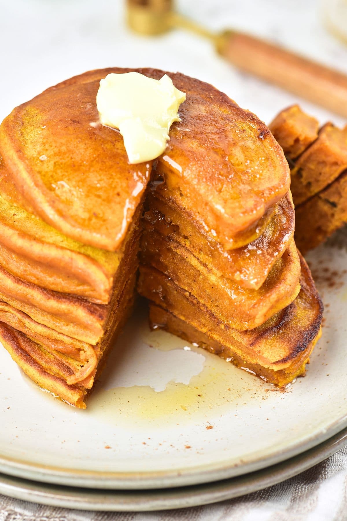 A stack of half-eaten fluffy gluten-free pumpkin pancakes