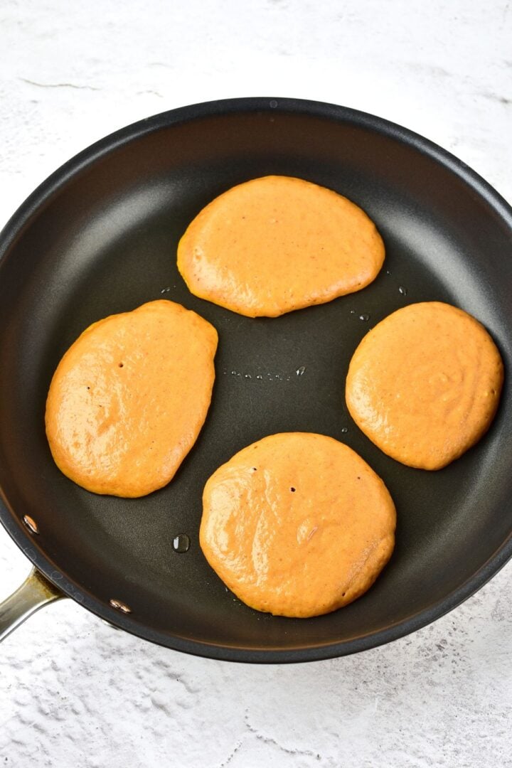 Cooking gluten-free pumpkin pancakes in skillet