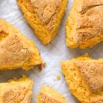 Top down view of soft tender pumpkin scones on parchment paper.