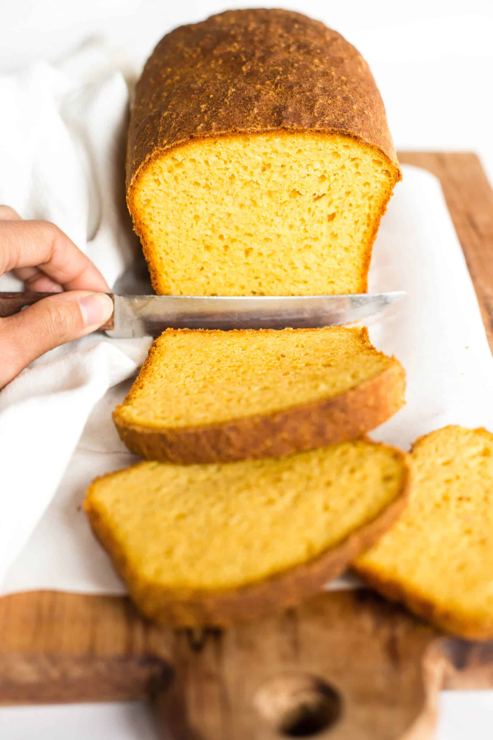 Slicing into a loaf of pumpkin bread with yeast.